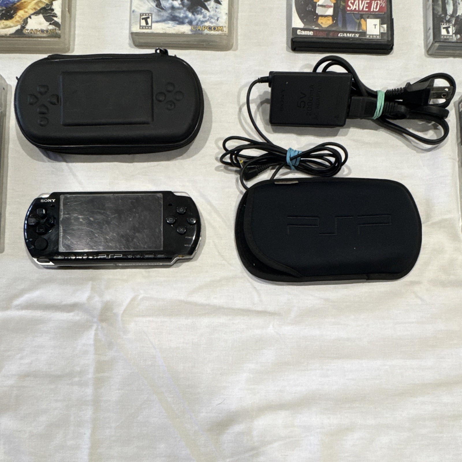 Sony PSP-1001 Black Handheld Console w/ Case, Charger & Game 6 UMD Bundle