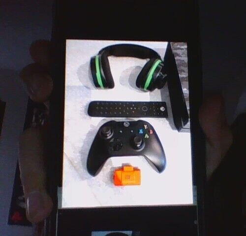 Gray Camo Xbox one with controller, headset, HDMI cord, charger, and a tv remote
