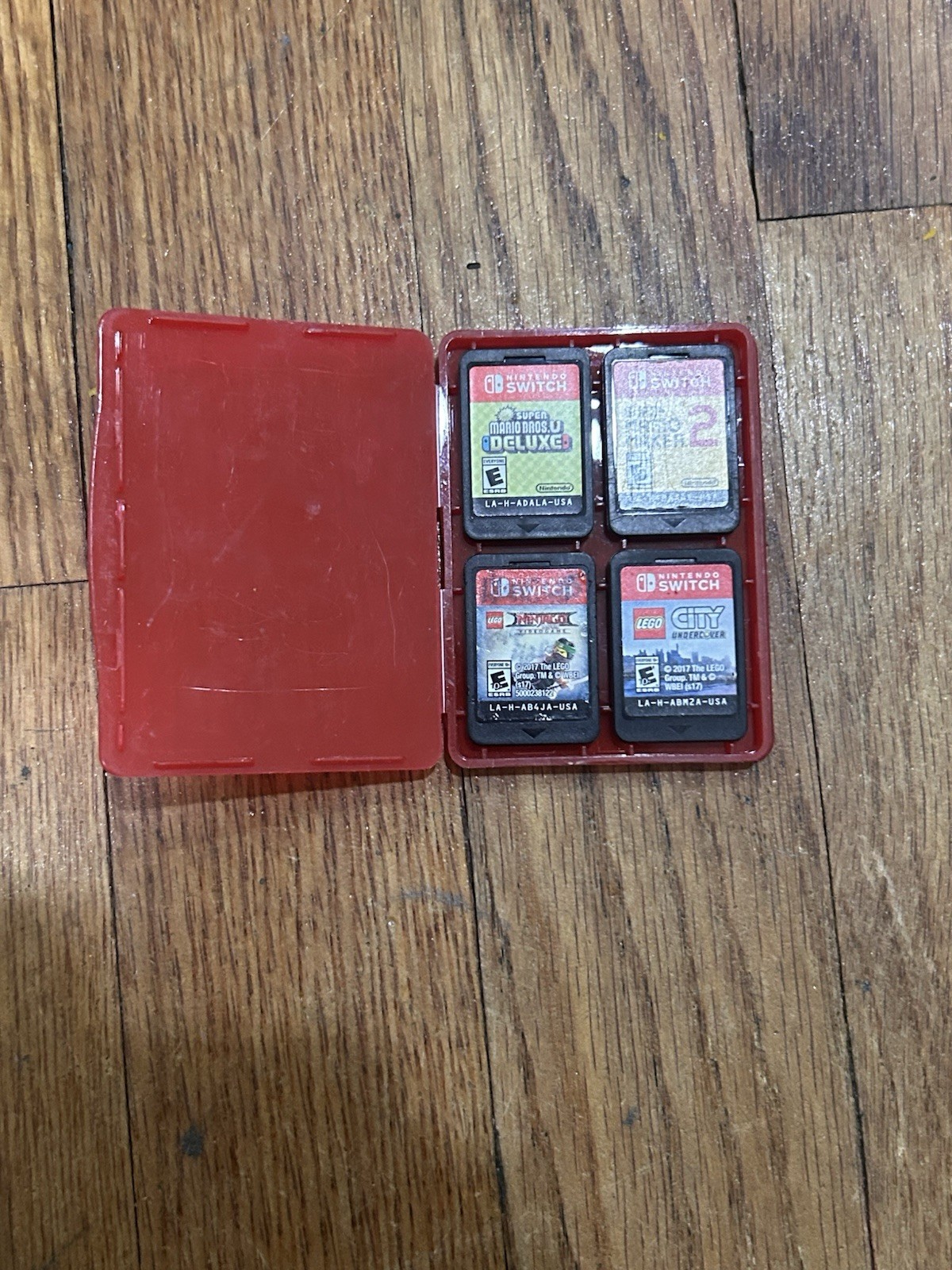 Nintendo Switch with joycon controllers, a charger, 4 games, and a game case.