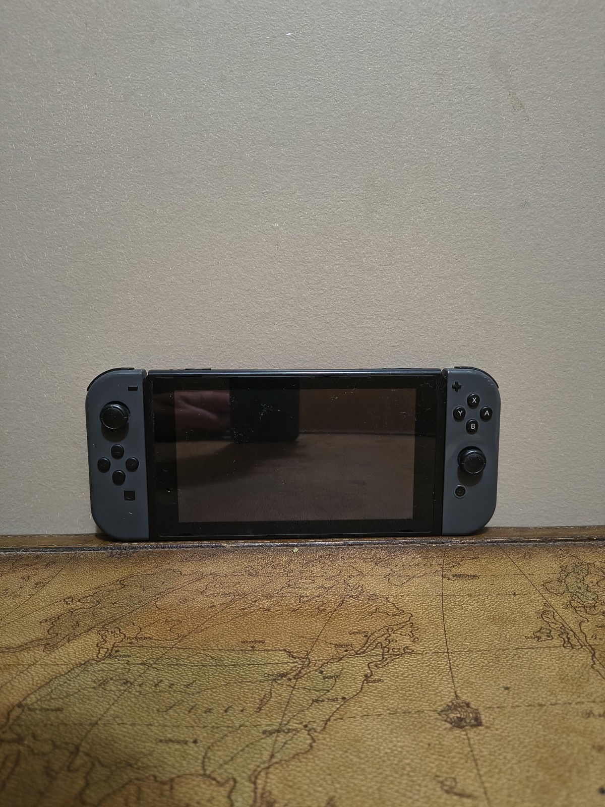 Nintendo Switch with joycon controllers, a charger, and a game case.