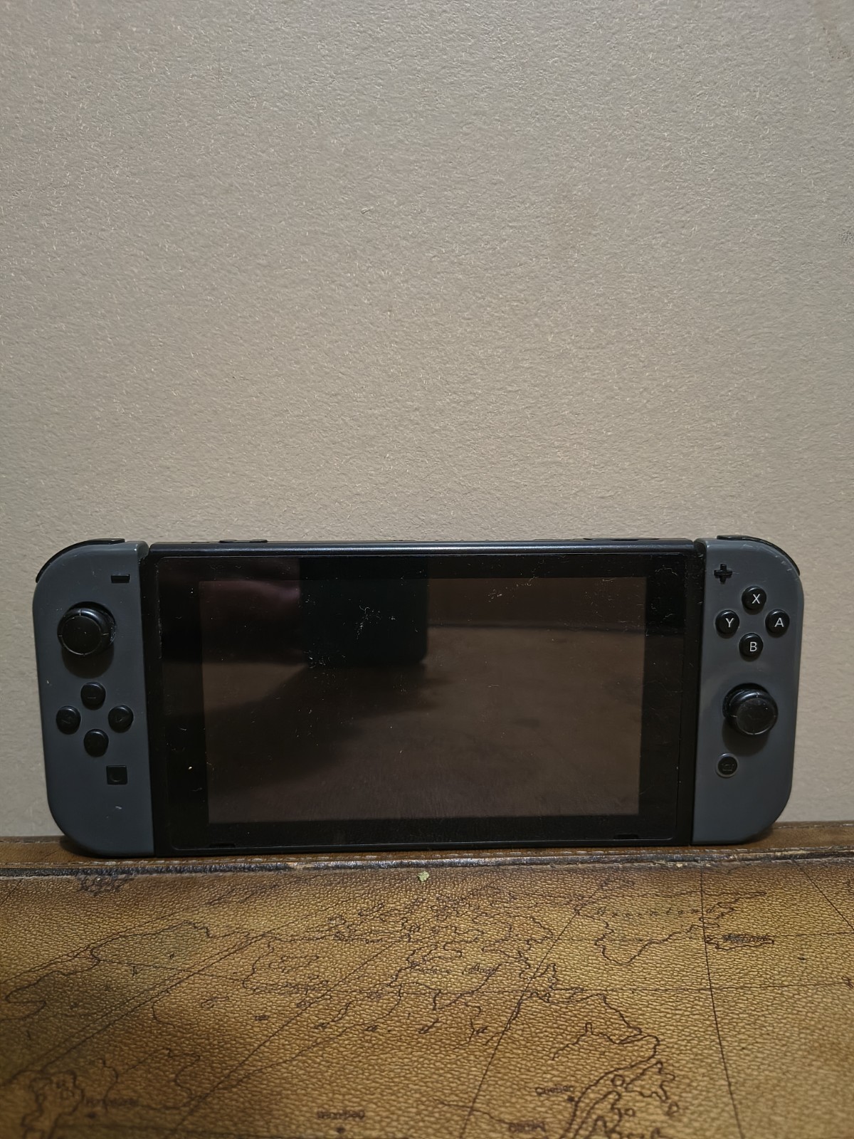 Nintendo Switch with joycon controllers, a charger, and a game case.
